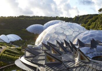 foto de uma área externa com muita natureza e edificações esféricas espelhadas