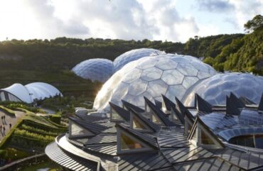 foto de uma área externa com muita natureza e edificações esféricas espelhadas