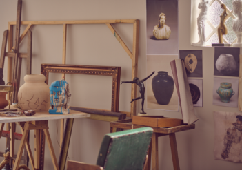 Fotografia de um estúdio de artes, com pinturas, esculturas e materiais diversos