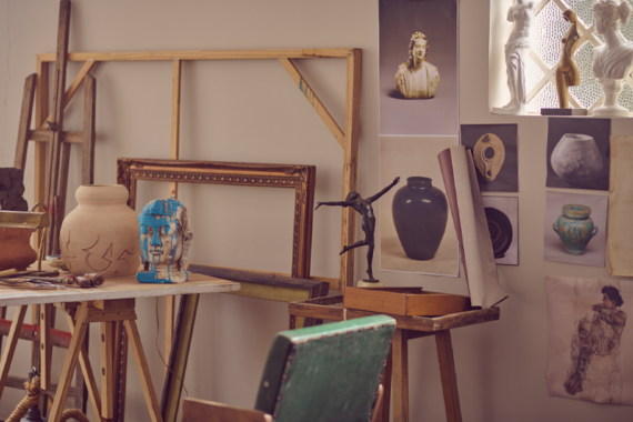 Fotografia de um estúdio de artes, com pinturas, esculturas e materiais diversos